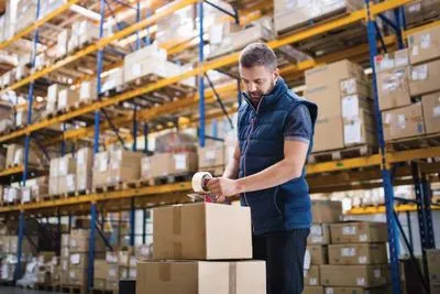 A person putting labels on packages in a warehouse